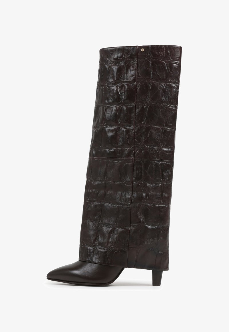 Cizmă din piele maronie, cu model de crocodil, cu vârf ascuțit și toc joasă. Prezintă un design unic al gâtului înalt și o suprafață texturată.
