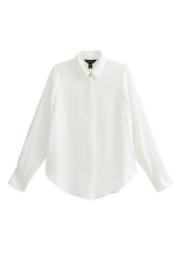 Camisa blanca de manga larga hecha de tela suave, presenta un cuello puntiagudo, cierre con botones y un dobladillo redondeado con mangas puñadas.