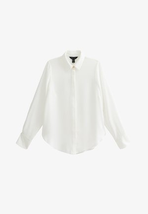 Biała koszula z długim rękawem wykonana z gładkiej tkaniny, posiadająca szpiczasty kołnierzyk, zapięcie na guziki oraz zaokrąglony dół z mankietowanymi rękawami.