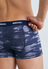 Námornícke modré boxer šortky s textúrovaným abstraktným vzorom, elastický pás s logom "DIESEL" a priliehajúci strih.