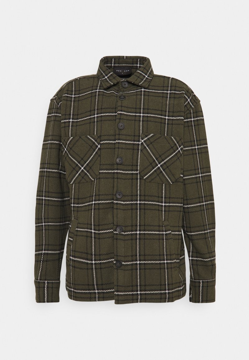 Chemise en flanelle à carreaux verts, dotée d'une fermeture boutonnée sur le devant, de deux poches poitrine et de boutons noirs avec un motif à carreaux blancs.