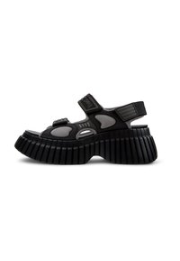 Sandali platform neri e grigi con punta aperta, cinturini in velcro e suola rigida. La parte superiore presenta forme ritagliate per la ventilazione.