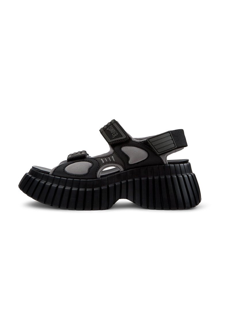 Sandali platform neri e grigi con punta aperta, cinturini in velcro e suola rigida. La parte superiore presenta forme ritagliate per la ventilazione.