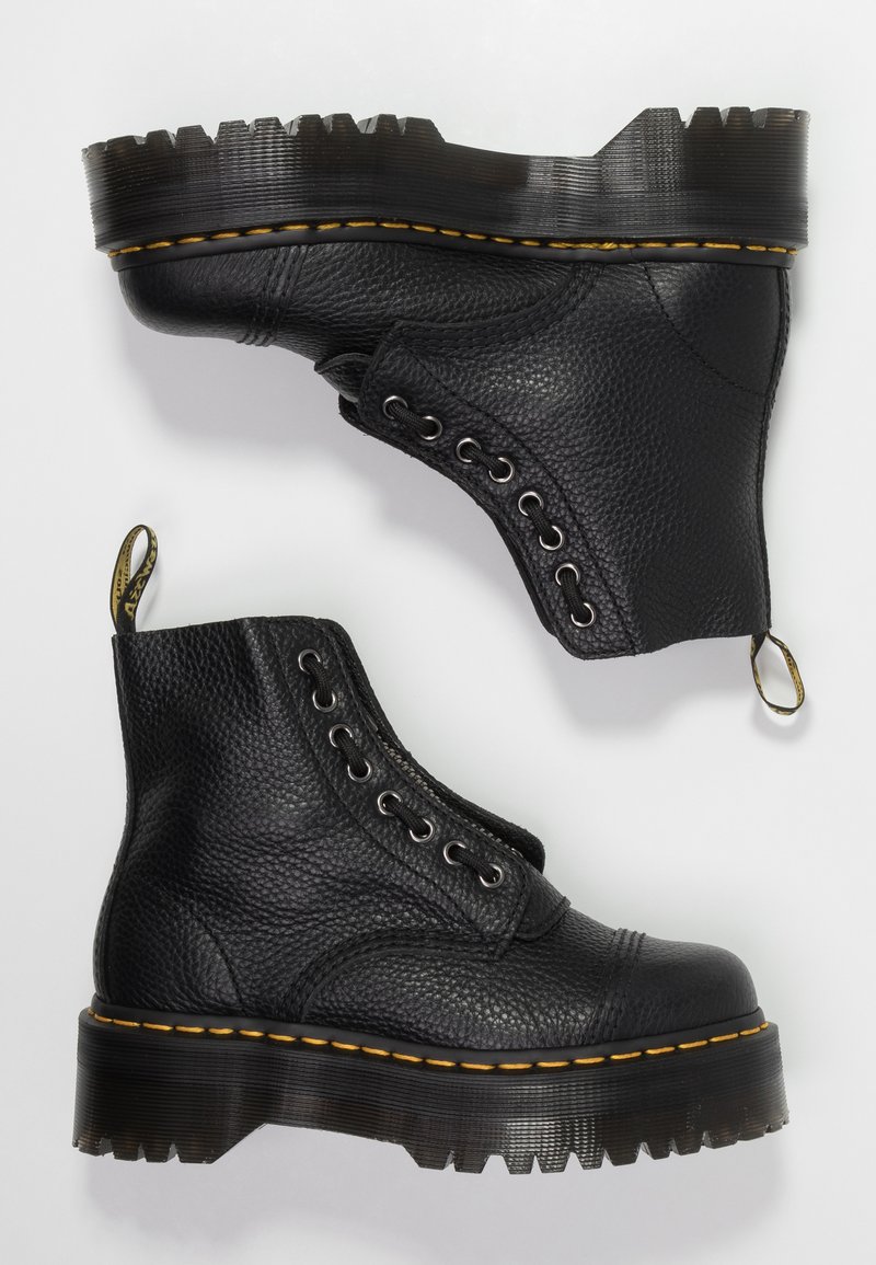 Black leather ankle boots with a textured finish, round toe, lace-up design, yellow accents along the sole, and chunky ridged platform.