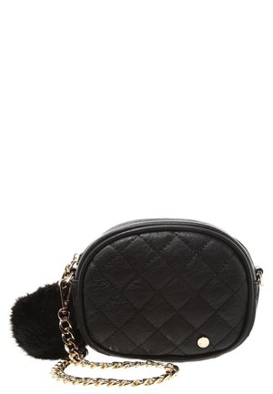 Petit sac en cuir matelassé noir avec une chaîne dorée et un pompon noir attaché à la fermeture éclair.