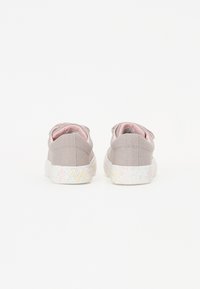 Baskets en toile gris clair avec un intérieur rose et une semelle blanche décorée d'un motif floral multicolore.
