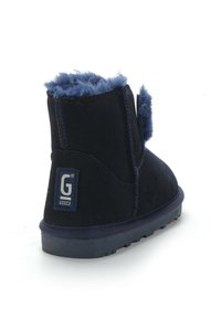 Stivaletti alla caviglia in suede blu navy con una morbida fodera in pelliccia, suola piatta e un'etichetta con il logo G sul retro, con un tacco leggermente sollevato.