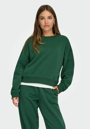 Green sweatshirt with a round neckline and dropped shoulders. Soft fabric and relaxed fit, paired with matching green sweatpants.