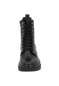Botas de cuero negras hasta el tobillo con ojetes en tono dorado, cordones en la parte frontal y una cremallera externa en el lado. Suela de goma texturizada para mayor tracción.