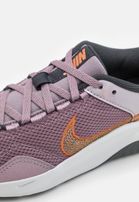 Violetti verkkomallinen lenkkari oransseilla ja kultaisilla yksityiskohdilla, mustilla nauhoilla ja tekstuurilla varustetulla pohjalla. Varusteena pehmustettu nilkkaosa ja kontrastiväreillä ommellut yksityiskohdat.