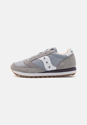 Szaro-białe niskie sneakersy z zamszowymi detalami, białym logo po boku, wiązane i z gumową podeszwą.