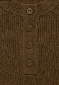 Brązowy prążkowany materiał w stylu henley, z czterema ciemnobrązowymi guzikami przy dekolcie i teksturowaną powierzchnią.