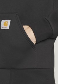 Sudadera negra con capucha y bolsillo tipo canguro. Presenta puños y dobladillo de canalé. Etiqueta con logo amarillo en el bolsillo para el branding.