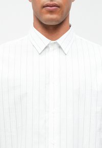 Hvit skjorte med tynne marineblå striper, med klassisk krage og teksturert stoff. Seks knapper er synlige foran.