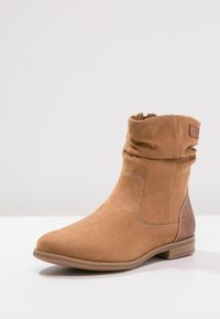 Braune Wildleder-Ankle Boots mit einem lässigen Schaft, abgerundeter Zehenpartie und strukturiertem Rückenteil. Mit kontrastierenden Nähten und einem niedrigen Blockabsatz.