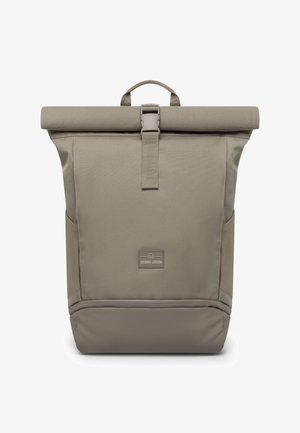 Mochila con cierre enrollable en tela beige apagado, con superficie texturizada, cierre central con clip, bolsillos laterales y parche con logotipo en la base.