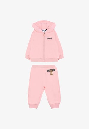 Roze katoenen trainingspak bestaande uit een ritsgevende hoodie met een berenafbeelding en logo, gecombineerd met tapershirts, beiden met ribgebreide boorden.