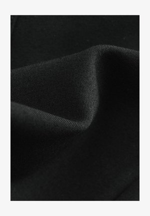 Czarna tkanina o miękkiej teksturze, cechująca się gładką powierzchnią i lekką elastycznością, podkreślona subtelnymi detalami w szwie.