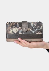 Cartera con un estampado floral en cuero suave, que cuenta con una banda de acento en marrón oscuro, un cierre metálico a presión y un detalle del logo en plata.