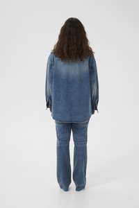 Set in denim con giacca e pantaloni in un lavaggio blu medio, caratterizzato da una vestibilità rilassata, maniche lunghe e un taglio dritto. Tessuto testurizzato.