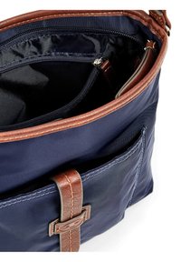 Interno di una borsa in tessuto navy con dettagli in pelle marrone, dotata di una tasca con zip e di un vano aperto, che mostra i dettagli delle cuciture.