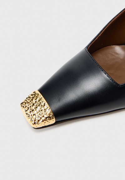 Pantof plat din piele neagră cu vârf ascuțit, având un vârf metalic auriu texturat și o căptușeală interioară netedă, maro.