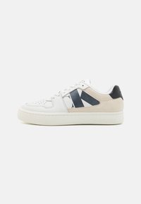 Vita sneakers med marinblå och beige accenter. Slät läder med perforeringar på tån, med en framträdande logotyp på sidan. Gummisula.