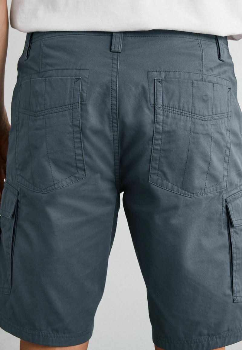 Graue Cargoshorts aus leichtem Stoff, mit zwei großen Gesäßtaschen und seitlichen Cargotaschen, in lockerer Passform und geradem Bein.