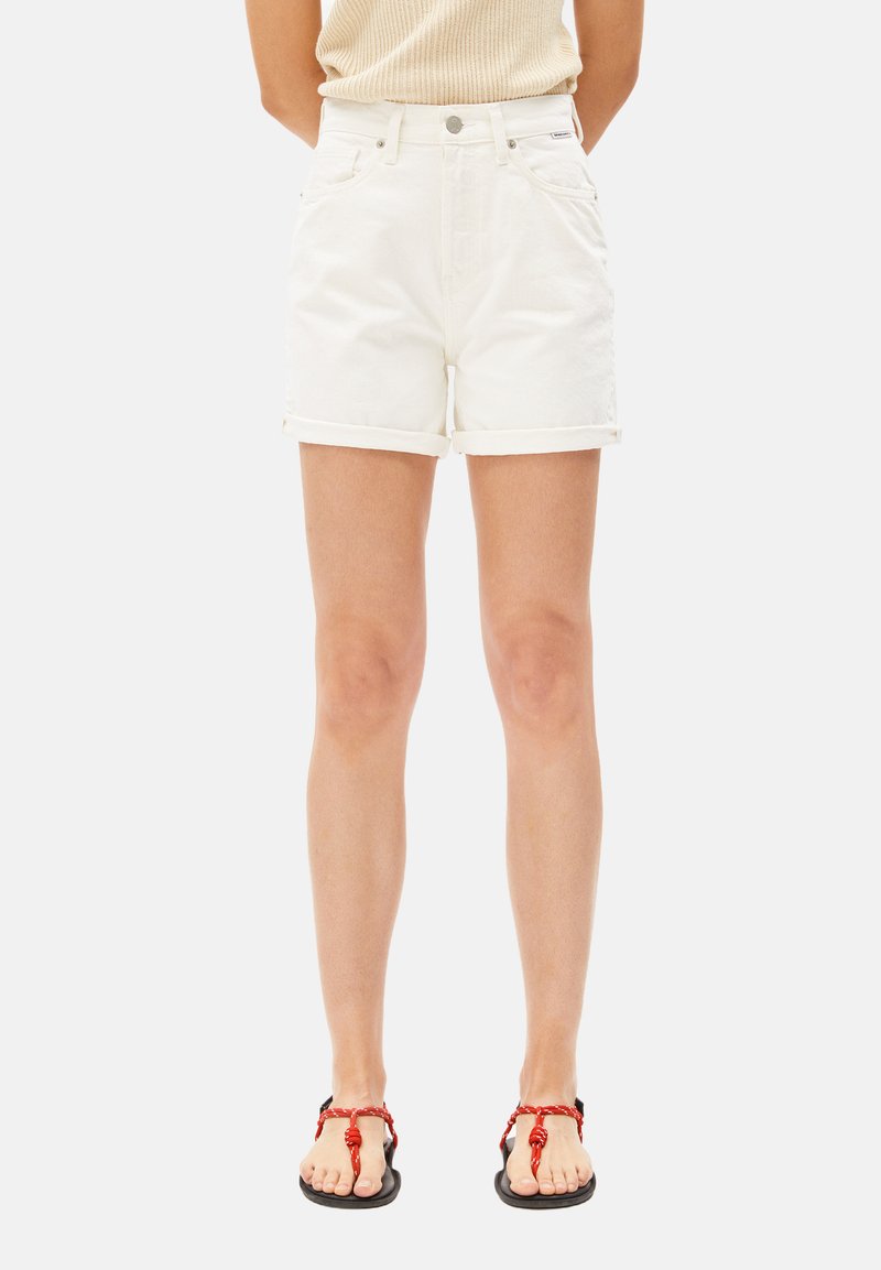 Witte denim shorts met omgeslagen zomen en voorzakken, gecombineerd met zwarte sandalen met rode gedraaide banden.