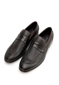 Bruine leren loafers met een visgraatstructuur, platte zool en een brede band over de wreef. Gladde accenten langs de randen.