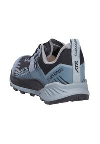 Lowa Ampia GTX Trail-Schuh mit einem Obermaterial aus schwarzem und hellblauem Textil, Gummisohle, strukturiertem Muster und einem Zugschlauf am Fersenbereich für einfaches An- und Ausziehen.
