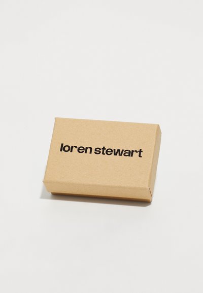 Smeđi kartonski kutija pravokutnog oblika, s natpisom "loren stewart" ispisanim podebljanim crnim slovima na gornjoj površini.