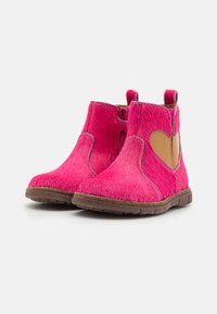 Bottines fuchsia à finition texturée, dotées d'une accent en forme de cœur couleur tan et d'une semelle en caoutchouc marron. Panneaux élastiques sur les côtés pour un enfilage facile.