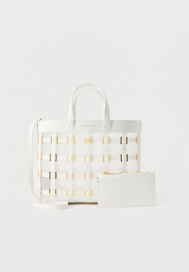 Λευκή δερμάτινη τσάντα χειρός με πλεκτές χρυσές λεπτομέρειες, διπλές λαβές, αποσπώμενο ιμάντα ώμου και αντίστοιχο φερμουάρ εμπρός.