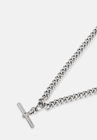 Strieborný kovový náhrdelník s prepojenými článkami a T-tvarovaným zapínaním, ktorý sa vyznačuje hladkým povrchom a lesklým finišom.