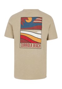 Camiseta de manga corta beige que presenta un gran gráfico de estilo retro en la parte posterior, con varias líneas onduladas de colores y un sol.