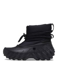 Svart vanntett støvel med polstret overdel, snøring med trekkspill og tykk zigzag såle for godt grep og støtte. Teksturert gummimateriale.