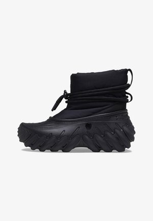 Stivale impermeabile nero con tomaia imbottita, chiusura con cordino e suola spessa a zigzag per trazione e supporto. Materiale in gomma testurizzata.