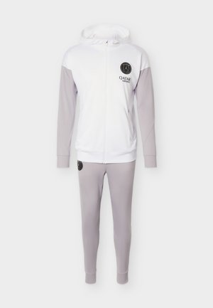 Bílá a světle šedá bunda s kapucí na cel zip a odpovídající kalhoty, s logy Paris Saint-Germain a Qatar Airways.