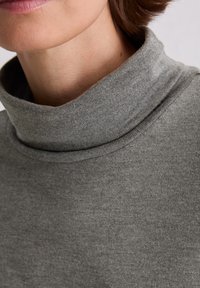 Grauer Rollkragenpullover aus weichem Material mit glatter Textur. Verfügt über einen hohen Kragen und Rippendetails am Halsauschnitt.
