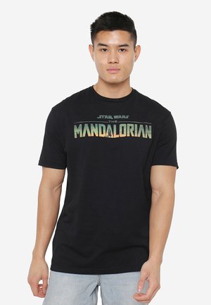 Black cotton t-shirt featuring "Star Wars The Mandalorian" graphic in green and orange. Short sleeves and crew neck design.