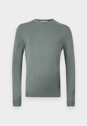 Svijetlozeleni pulover dugih rukava napravljen od mekog pletenog materijala. Ima okrugli izrez i uske rukave s rebrastim manžetama. Jednostavan dizajn.