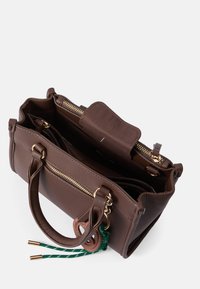 Hnedá kožeňaná kabelka so zlatými zipsami, dvojitými uchami a dekoratívnymi zelenými a hnedými akcentmi. Interiér obsahuje viacero priehradiek.