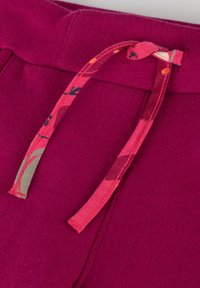 Fuchsia Jogginghose mit einem gerippten Bund und einem gemusterten Kordelzug mit rosa und grünen Akzenten. Weicher, strukturierter Stoff.