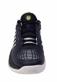 Zapatilla deportiva de color azul marino con acentos blancos, parte superior de malla y suela texturizada. Presenta un logo en la lengüeta y los cordones para un ajuste seguro.