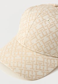 Casquette de baseball beige avec un motif géométrique texturé dans une teinte de beige légèrement plus foncée.