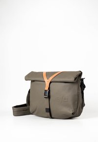 Borsa messenger impermeabile verde con chiusura a rotolo, manico in pelle e tracolla regolabile; presenta un marchio discreto sul lato.