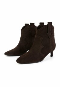 Stivaletti alla caviglia in suede marrone con punta affusolata, dettagli di cucitura sottili e piccoli tacchi a blocco. Le aperture laterali migliorano il design.