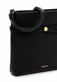 Czarna skórzana torebka o fakturowanej powierzchni, z okrągłym uchwytem i złotym zatrzaskiem. Logo umieszczone blisko dołu.