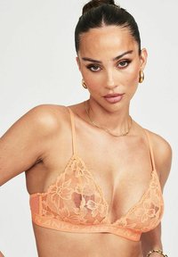 Lace driehoekige bh in perzik met doorschijnende stof, bloemenpatroon, verstelbare bandjes en een elastische band met de merknaam.